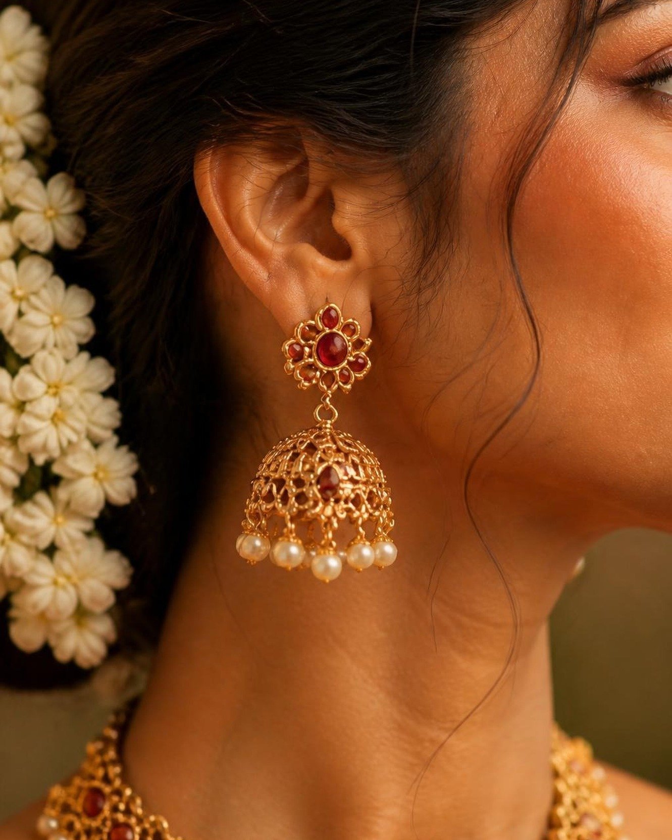 Model wearing a gold drop earring, close-up